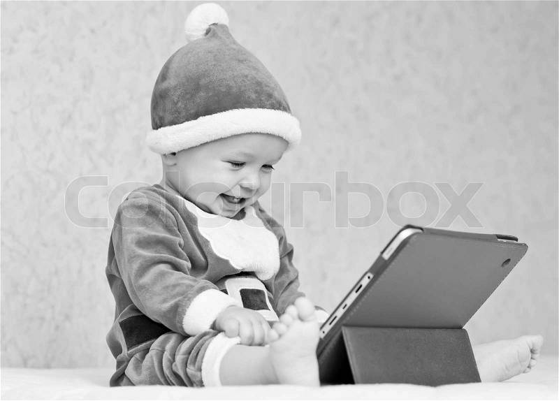 Happy santa helper baby boy with digital tablet ( black and white ), stock photo