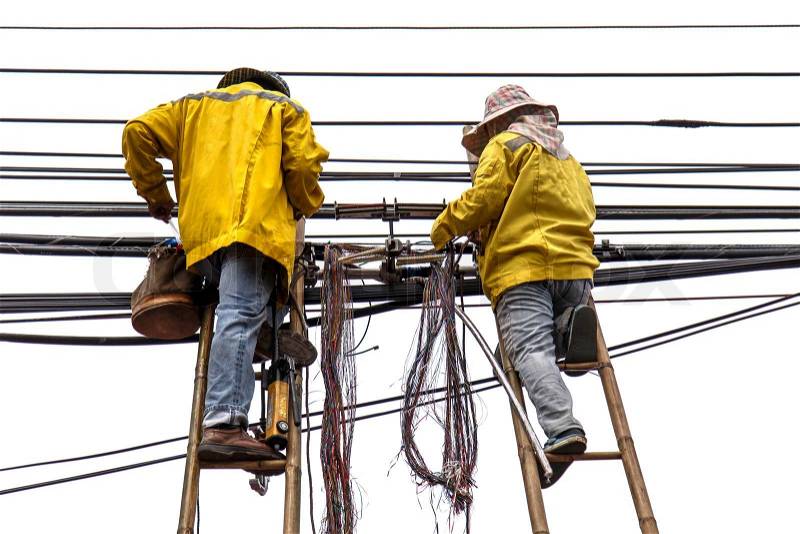 Worker on bamboo ladder is repairing telephone line, stock photo