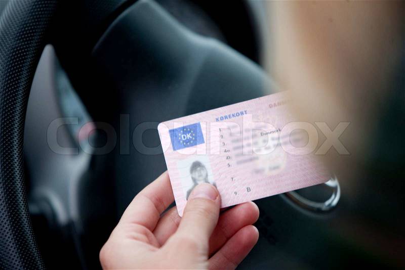 A female danish driver holding a driver's license, stock photo