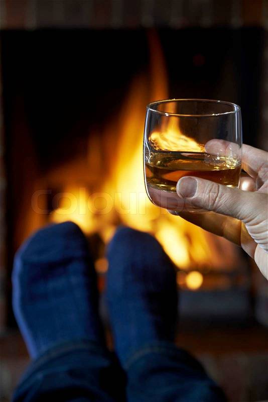 11856700-man-with-glass-of-whisky-relaxing-by-fire.jpg