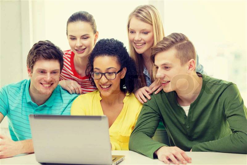 Education, technology and college concept - five smiling students looking at laptop at school, stock photo