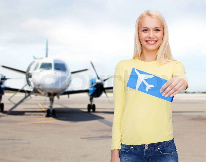 Travel, people and transportation concept - smiling young woman with airplane ticket at airport, stock photo