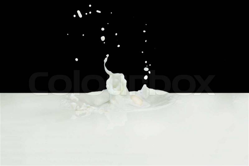 Splashing milk isolated on black background, stock photo