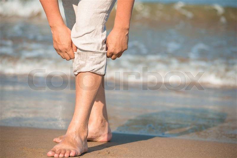 Barefoot male tuck pants not to wet, stock photo