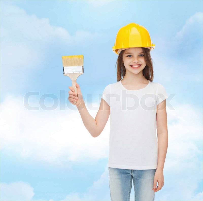 Painting, building, childhood and people concept - smiling little girl in protective helmet with paint brush, stock photo