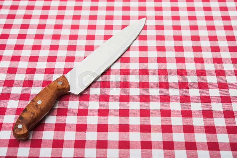 Big kitchen knife on tablecloth, stock photo