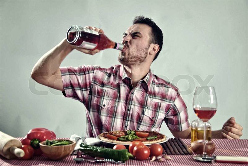 Crazy hungry man eating pizza in a restaurant, stock photo