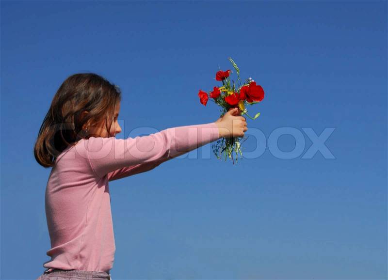 A little girl give flowers on a blue sky, stock photo