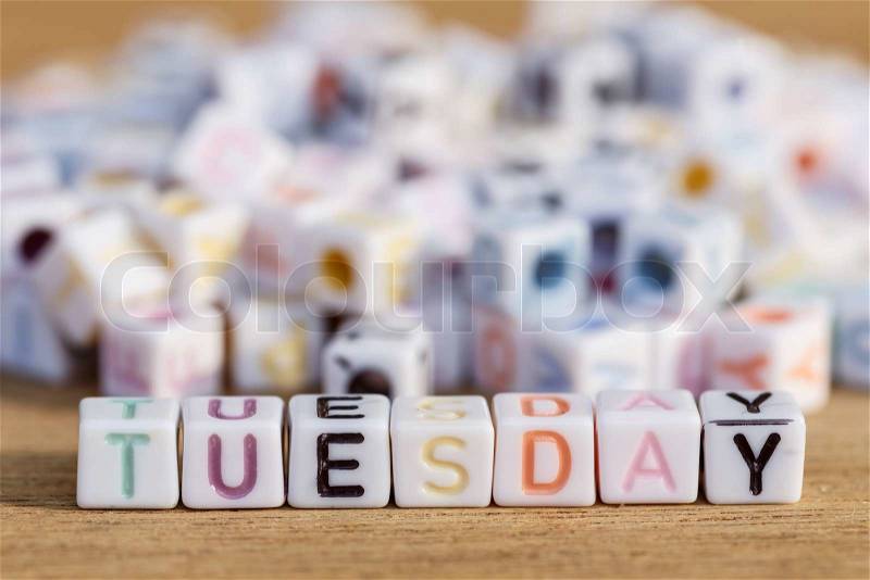 Tuesday written in letter beads on wood background, stock photo