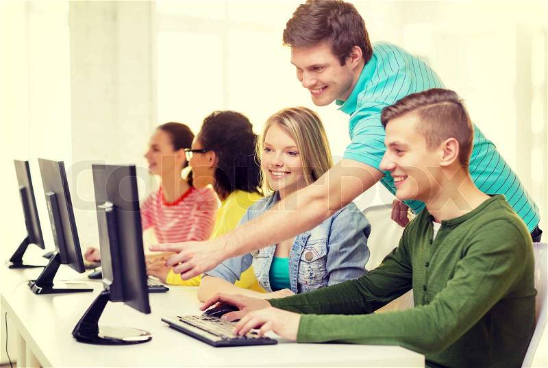 Education, technology and school concept - smiling students in computer class at school, stock photo