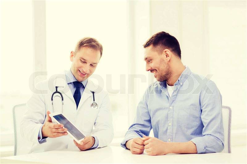 Healthcare, technology and medicine concept - smiling doctor with tablet pc computer and patient in hospital, stock photo