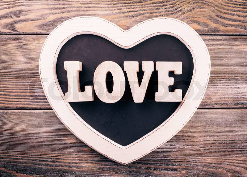 Wooden letters LOVE on heart shape chalkboard, stock photo