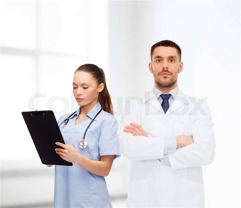 Healthcare, profession and medicine concept - group of doctors in white coats with clipboard and stethoscope over clinic background, stock photo