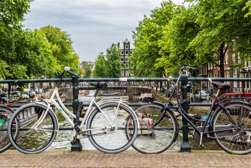 AMSTERDAM, NETHERLANDS - AUGUST 19: Bicycles on a bridge over the canals of Amsterdam. Amsterdam is the capital and most populous city of the Netherlands on August 19, 2014, stock photo
