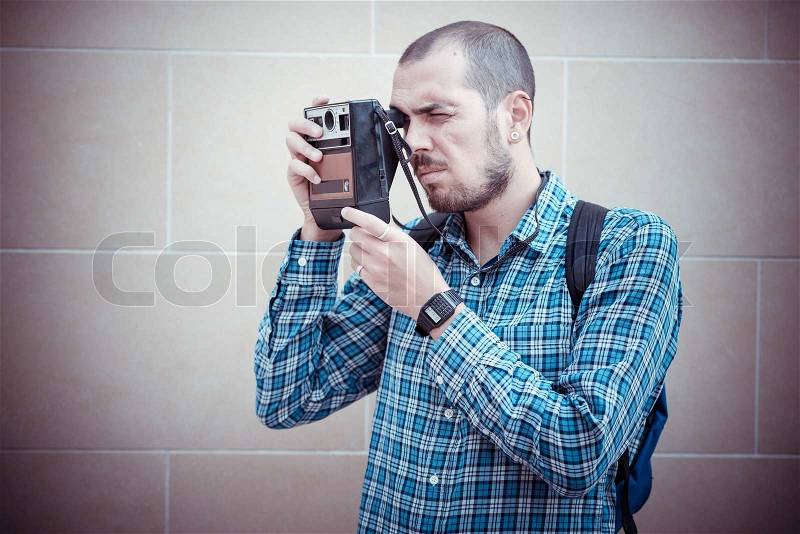 Handsome hipster casual multitasking modern man with vintage camera in the city, stock photo