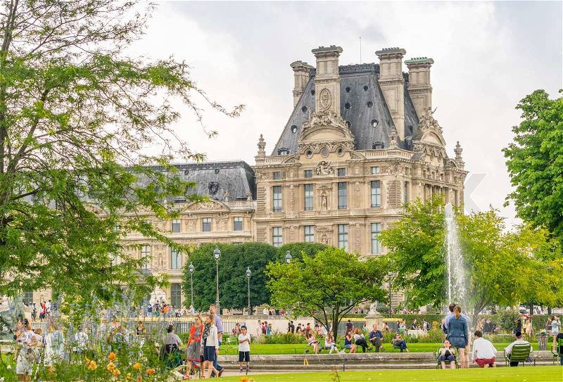 PARIS - JULY 20, 2014: Tourists walk along Tuileries Gardens in Paris. French capital is visited by more than 30 million people annually, stock photo