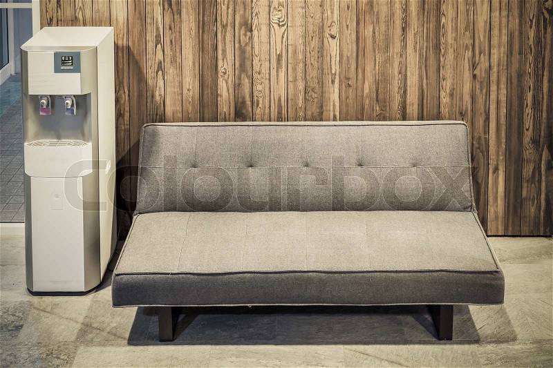 Sofa furniture and water cooler on wood texture background, stock photo