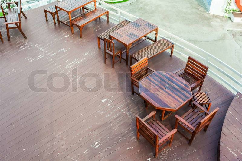Dining table on terrace beside white fence, top view, stock photo