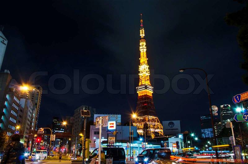 Tokyo, Japan - November 28, 2013: Busy street at night with Tokyo Tower in the distance in Tokyo, Japan on November 28, 2013, stock photo
