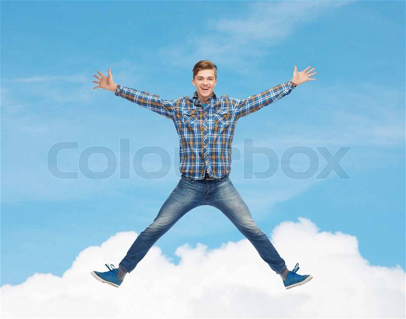 Happiness, freedom, movement and people concept - smiling young man jumping in air over blue sky with white cloud background, stock photo