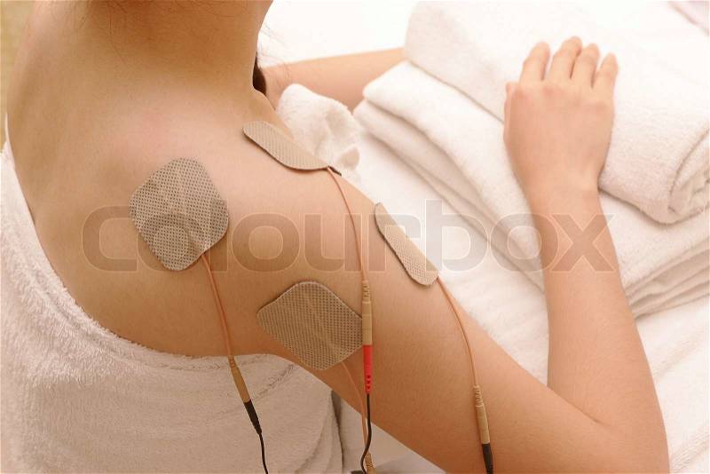 Asian woman is doing massage of electrical -stimulation ( TENs ) for the shoulder, stock photo