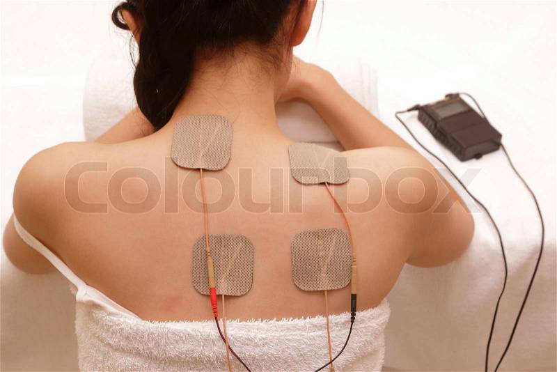 Asian woman is doing massage of electrical -stimulation ( TENs ) for the back, stock photo