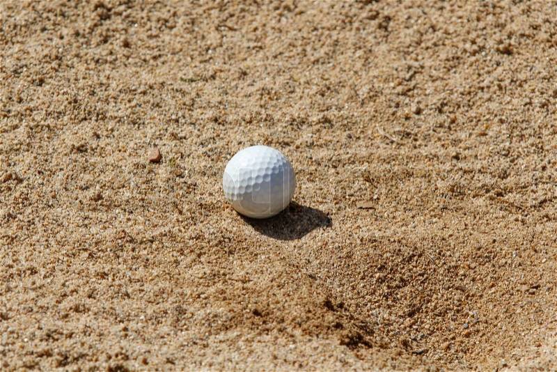 Golf ball in a sand trap, stock photo