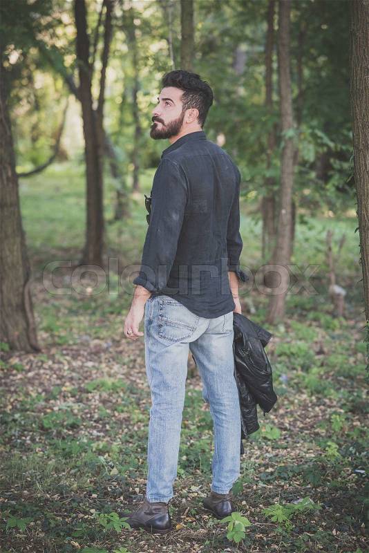 Young handsome attractive bearded model man in the woods, stock photo