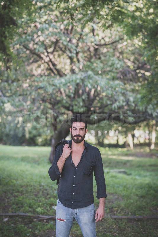 Young handsome attractive bearded model man in the woods, stock photo