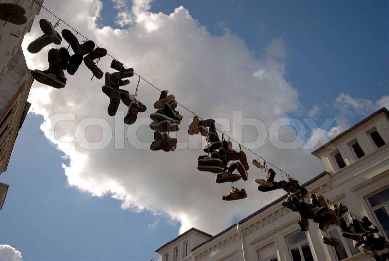 Old boots hanging from power cable in Flensburg, Germany, stock photo