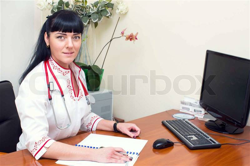 Woman doctor in a white coat in the office, stock photo