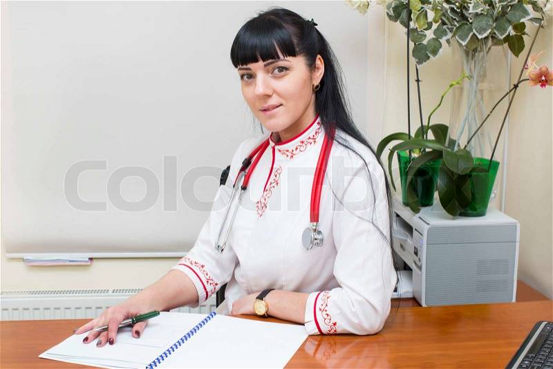 Woman doctor in a white coat in the office, stock photo