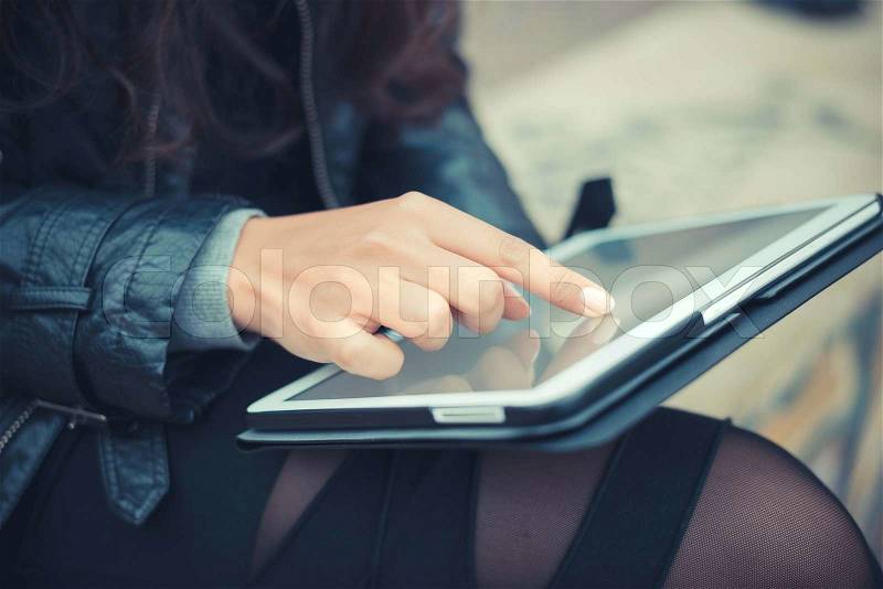 Close up of woman hands using tablet outdoors, stock photo