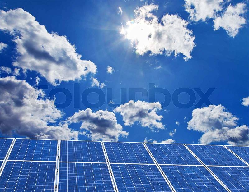 A solar system for solar energy against a blue sky with clouds, stock photo