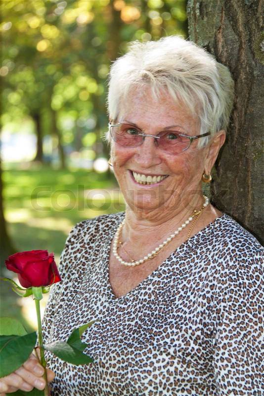 Happy older senior citizen with a red rose, stock photo