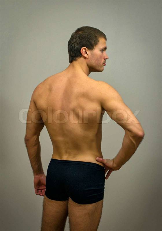 Muscular male model posing. Back view, stock photo