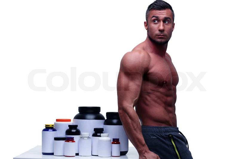 Muscular man leaning on the table with sports nutrition, stock photo