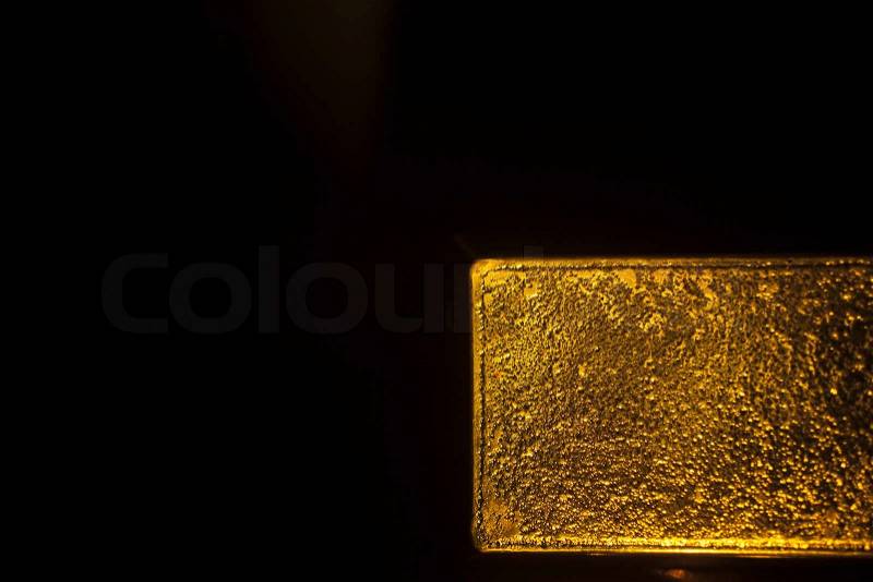 1 kg Gold bullion bar 999.9 on plain black studio background with publicity copy space. , stock photo