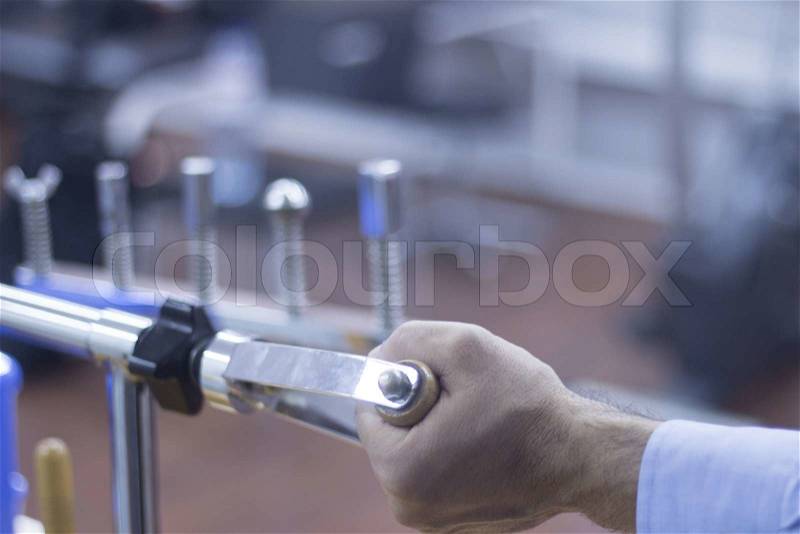 Hand of a male patient in physiotherapy rehabilitation treatment from orthopedic surgery in a hospital clinic physiotherapy room turning a wheel to build strength in his wrist muscles, stock photo