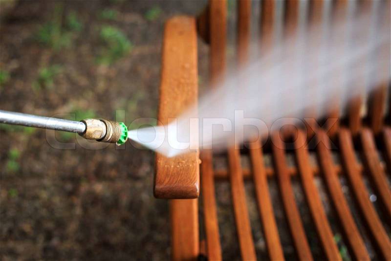 Wooden chair cleaning with high pressure water jet, stock photo