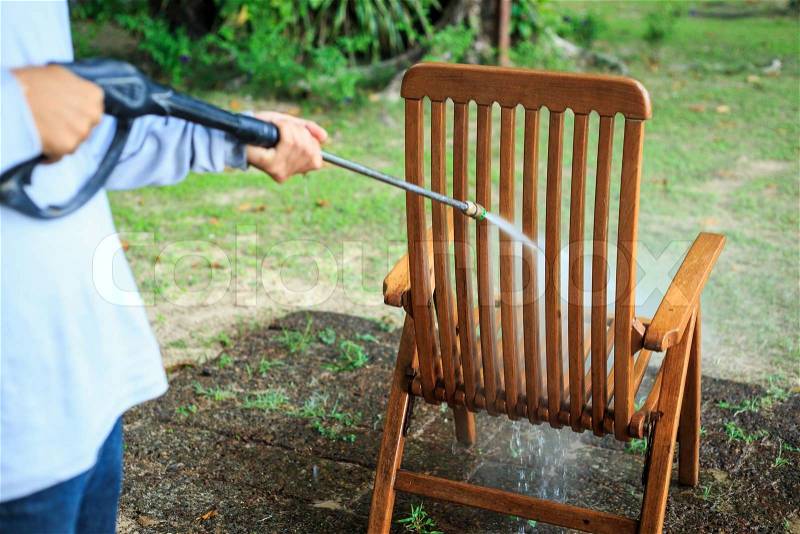 Wooden chair cleaning with high pressure water jet, stock photo