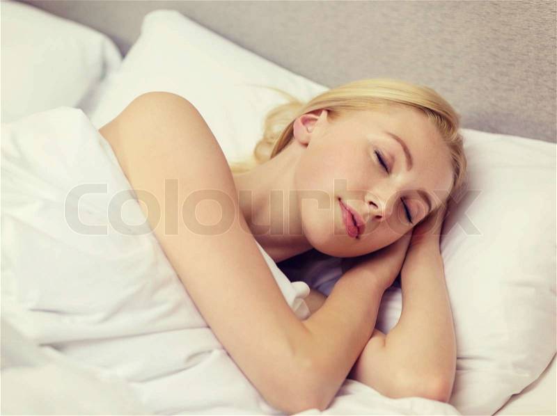 Hotel, travel and happiness concept - beautiful woman sleeping in bed, stock photo