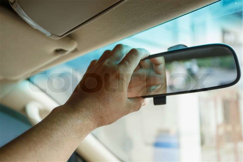 A hand holding mirror in the car, stock photo