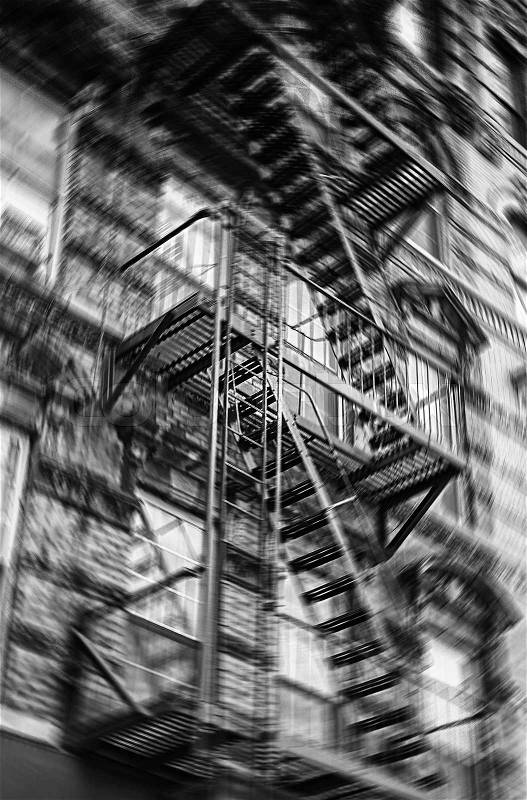 Motion blurred image of New York brick buildings with outside fire escape stairs, stock photo