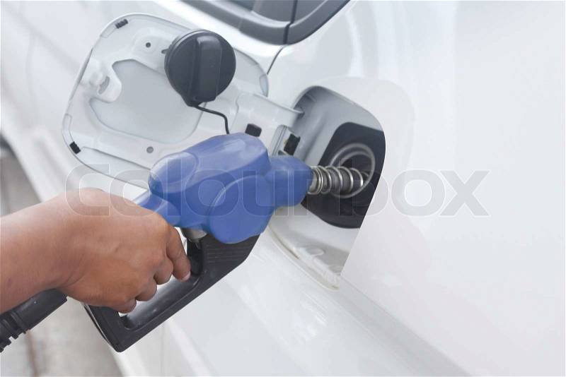 Background of hand filling up car fuel, stock photo