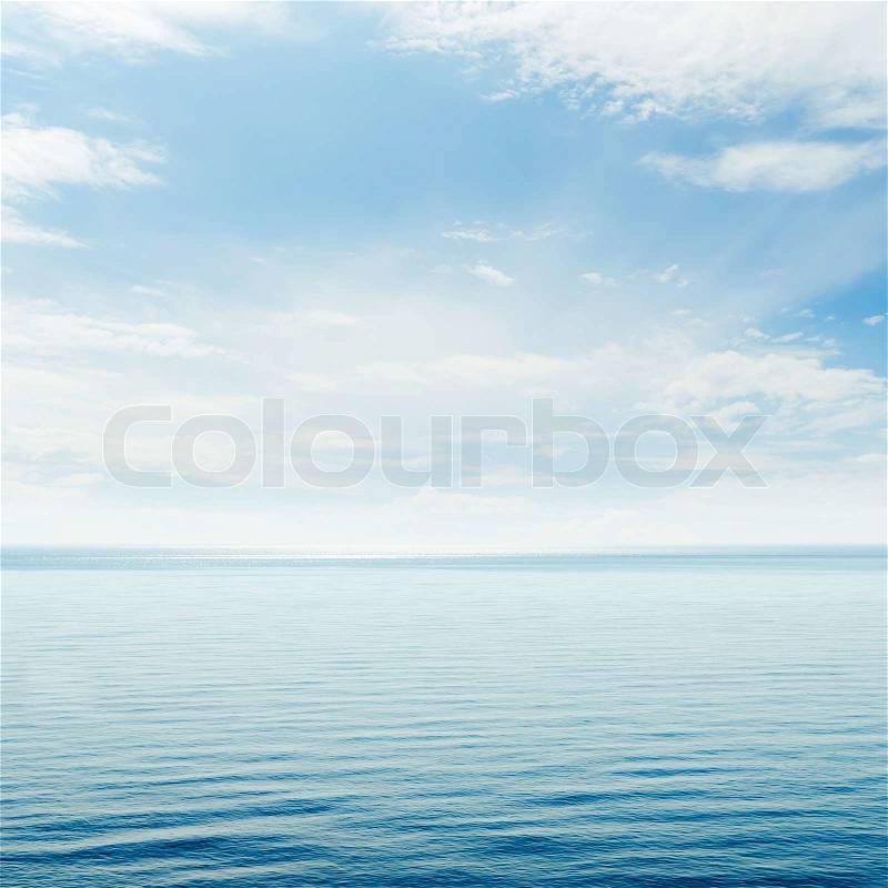Blue sea and cloudy sky over it, stock photo