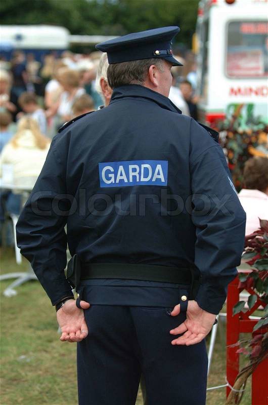Rear view of a police officer with people in the background, stock photo