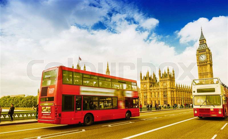 Two red buses crossing Westminter Bridge on a sunny day in London, stock photo