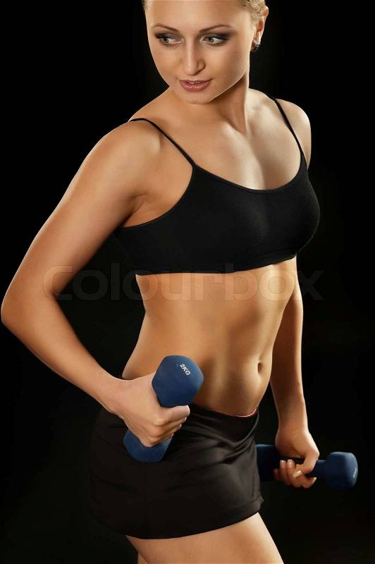 Portrait of young woman in sportswear on black background, stock photo