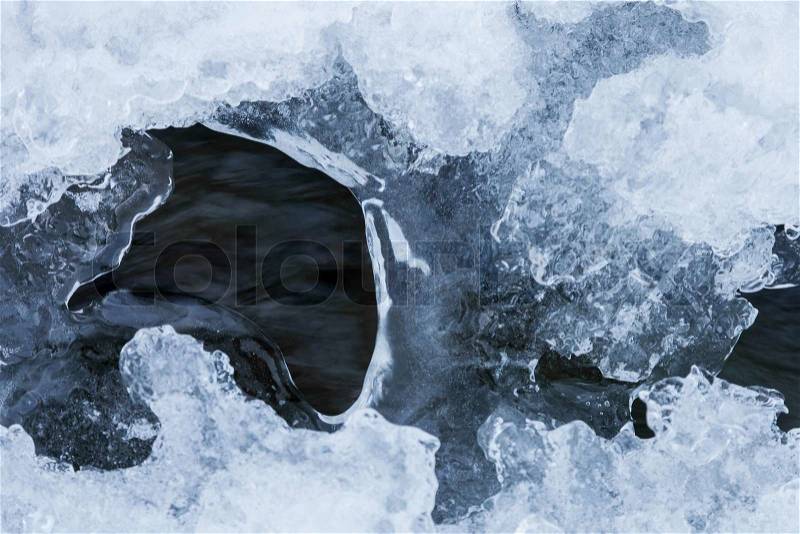 Beautiful view of flowing water under ice in winter, stock photo
